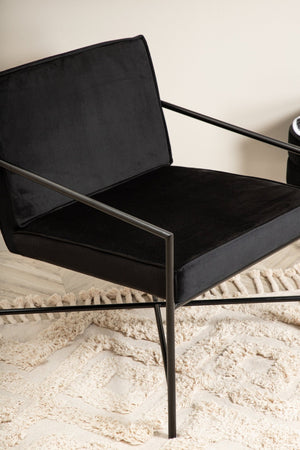 Fauteuil Rakel en velours noir et piètement acier en situation