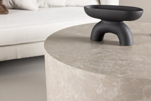 Table basse ronde York beige utilisée comme table basse de salon